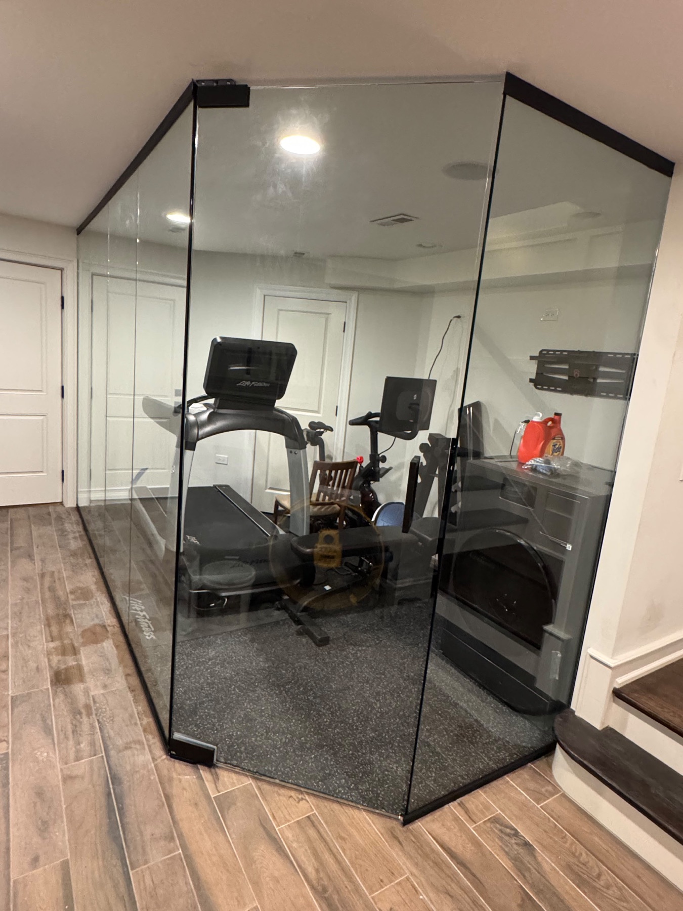 Completed Lake & Oak Gold Coast home gym with exercise equipment behind a glass enclosure with black framing